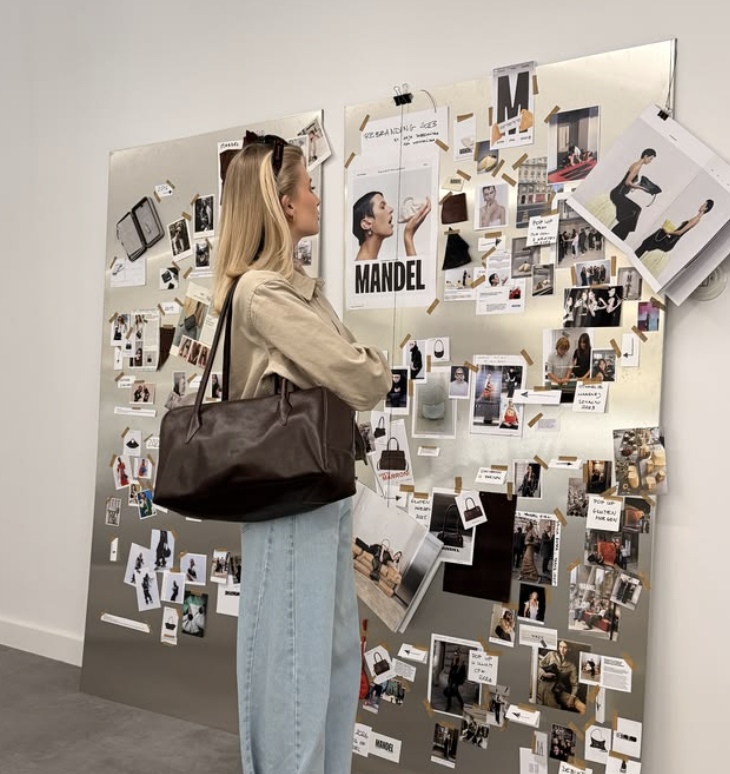 A founder studying a wall of brand inspiration